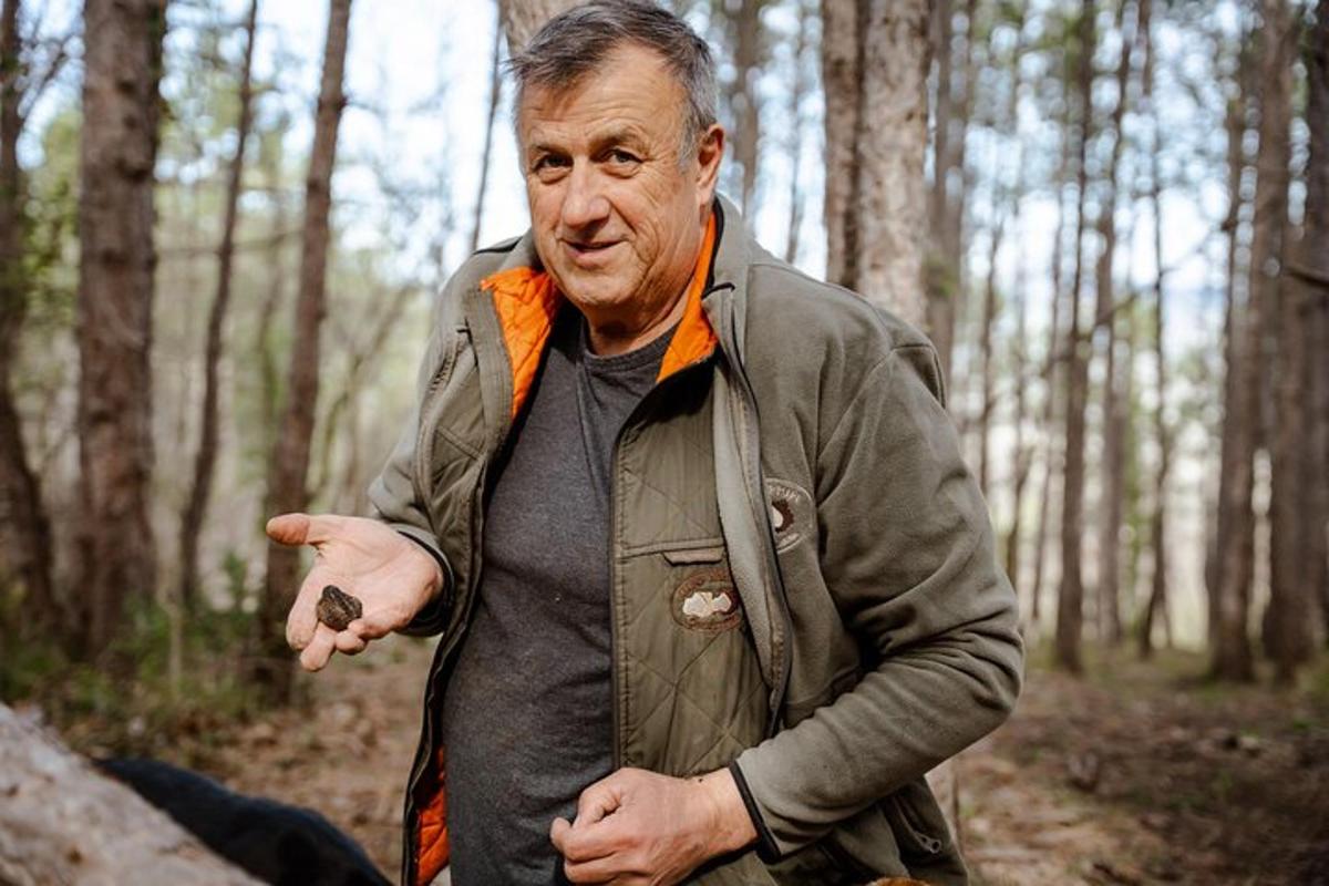 egy férfi áll az erdőben, mutat valamire