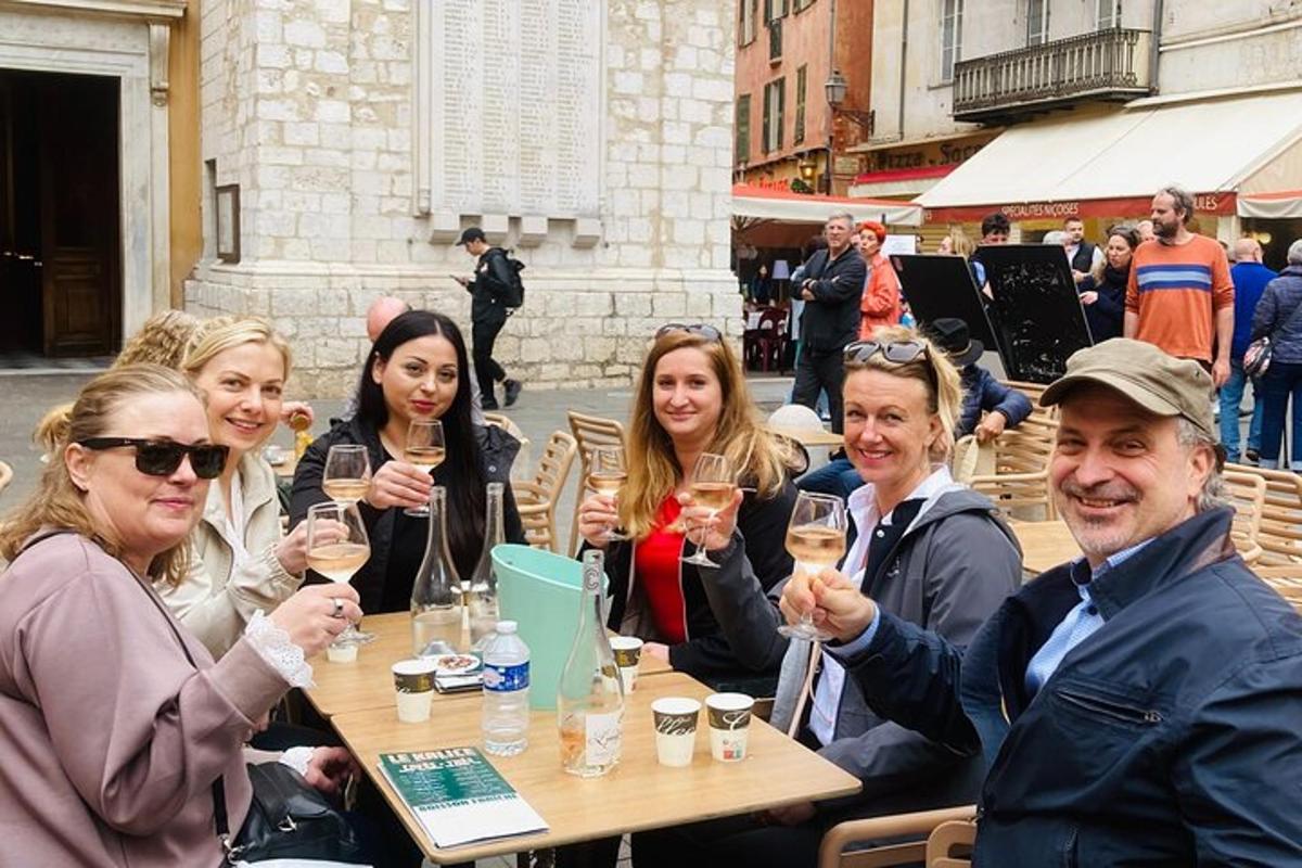 a group of people sitting at a table holding up wine glasses