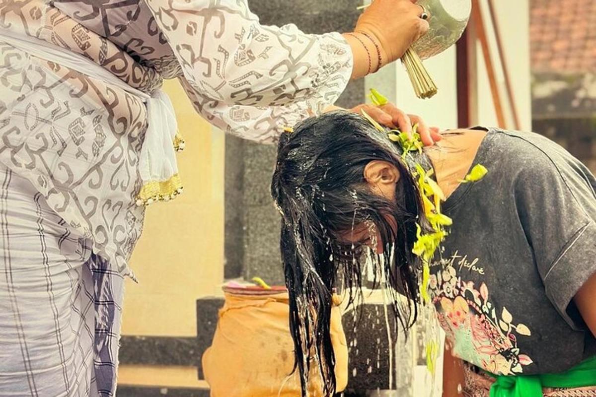 a woman is washing a mans hair with a brush