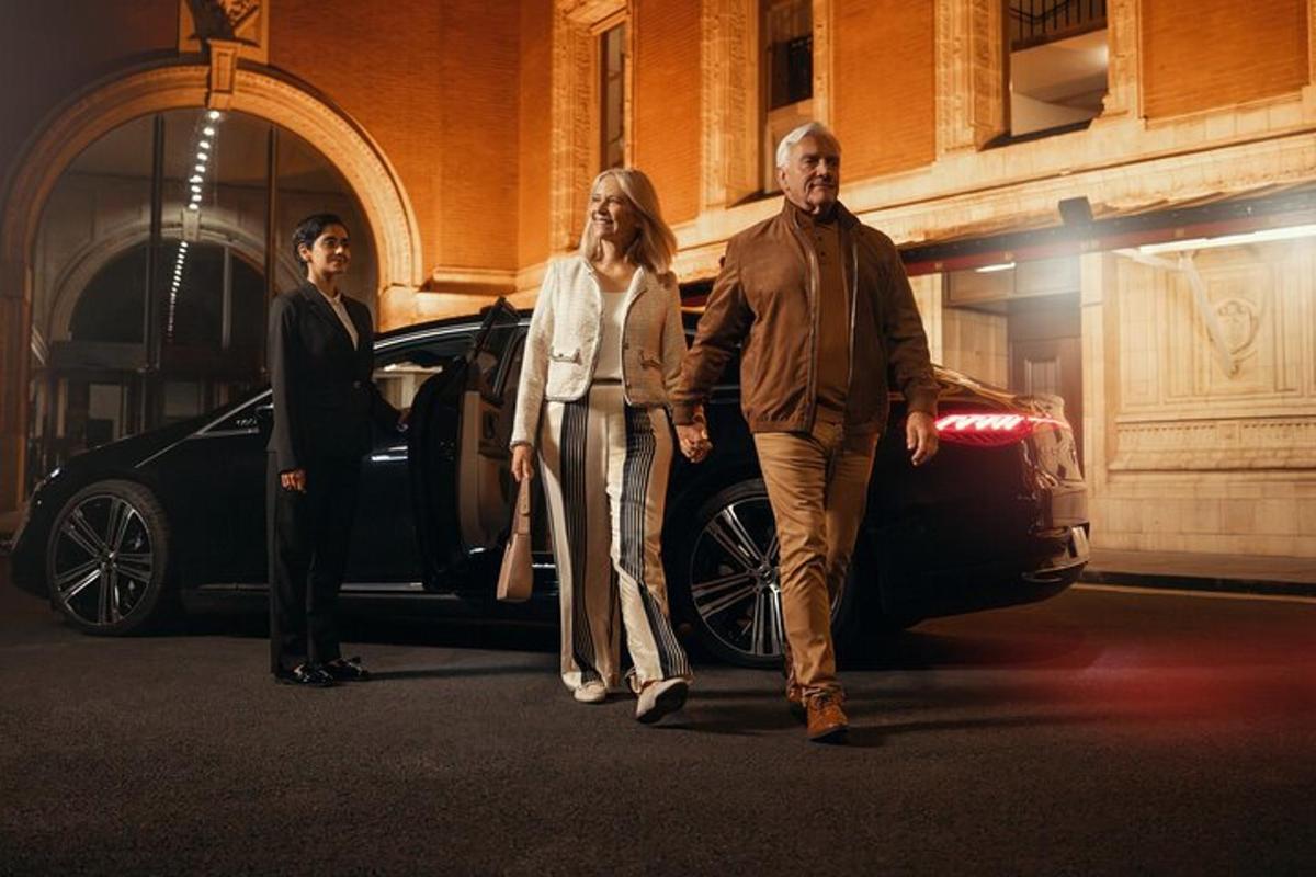 a man and a woman walking next to a car
