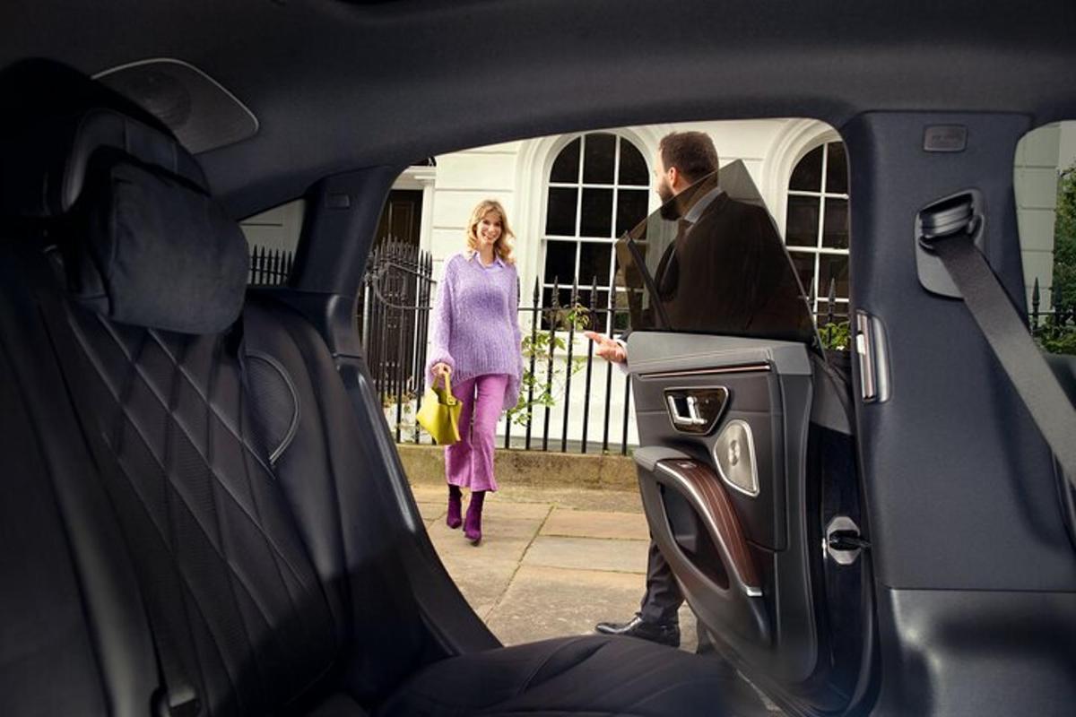 a man and a woman looking into the back of a car
