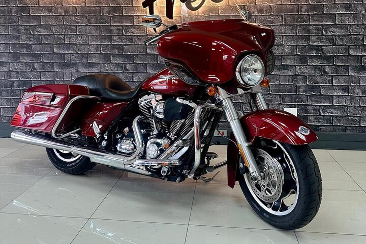 a red motorcycle parked next to a brick wall