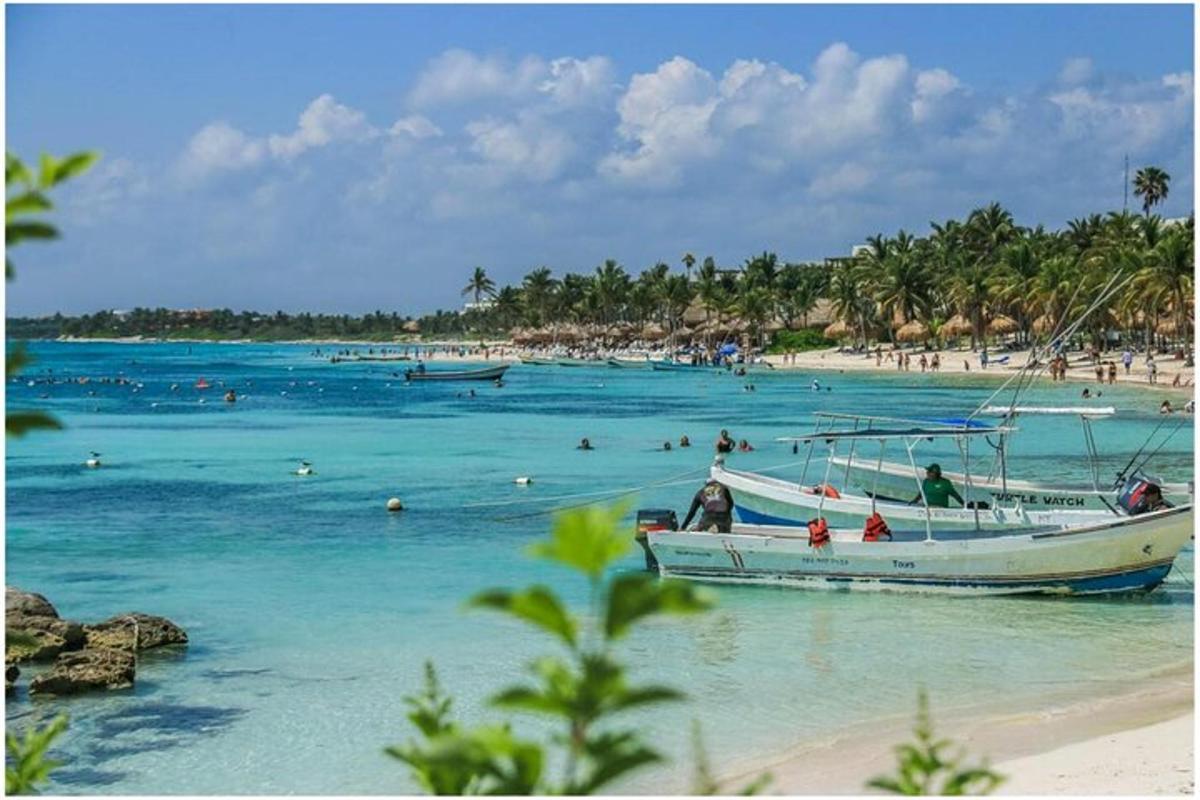 un barco en una playa con gente en el agua