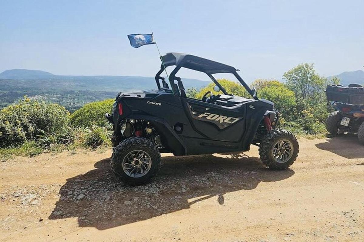 um quadriciclo preto estacionado em uma estrada de terra