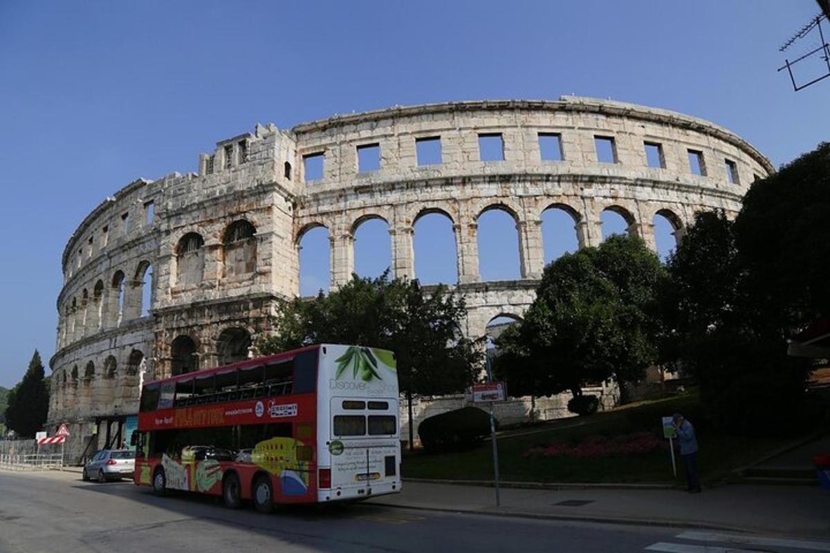 egy emeletes busz parkolt a Kolosszeum előtt