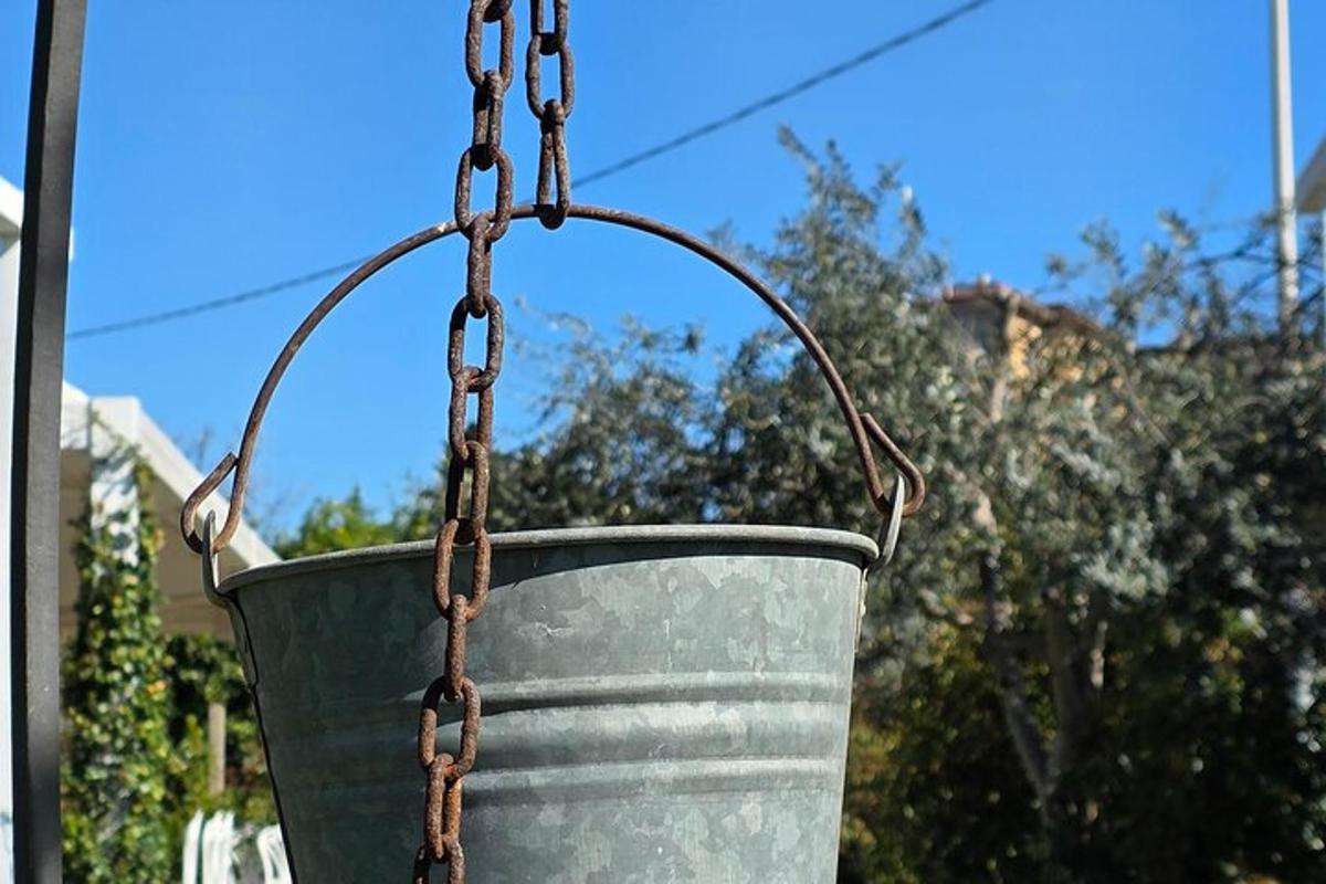 kovinsko vedro z verigo, obešeno na drog