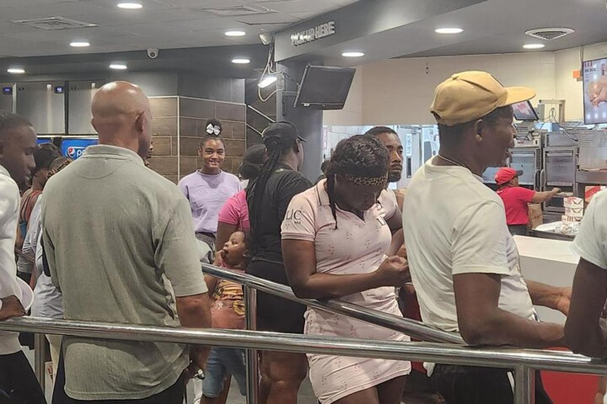 a group of people standing around a counter in a kitchen