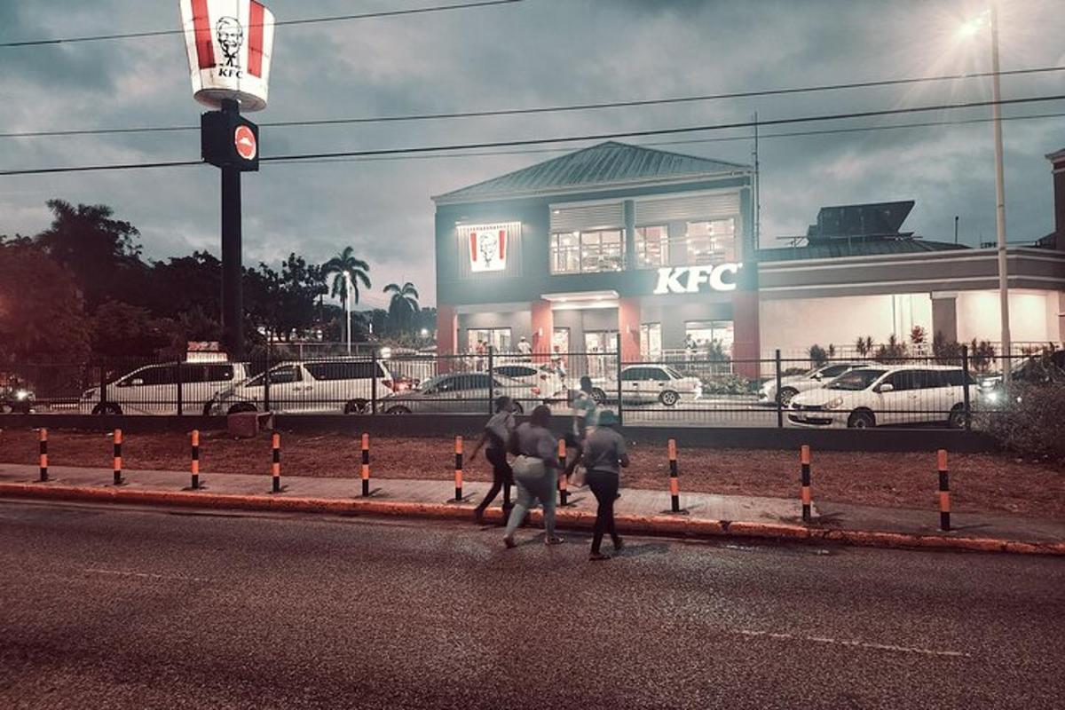 a group of people walking down a street with a traffic light