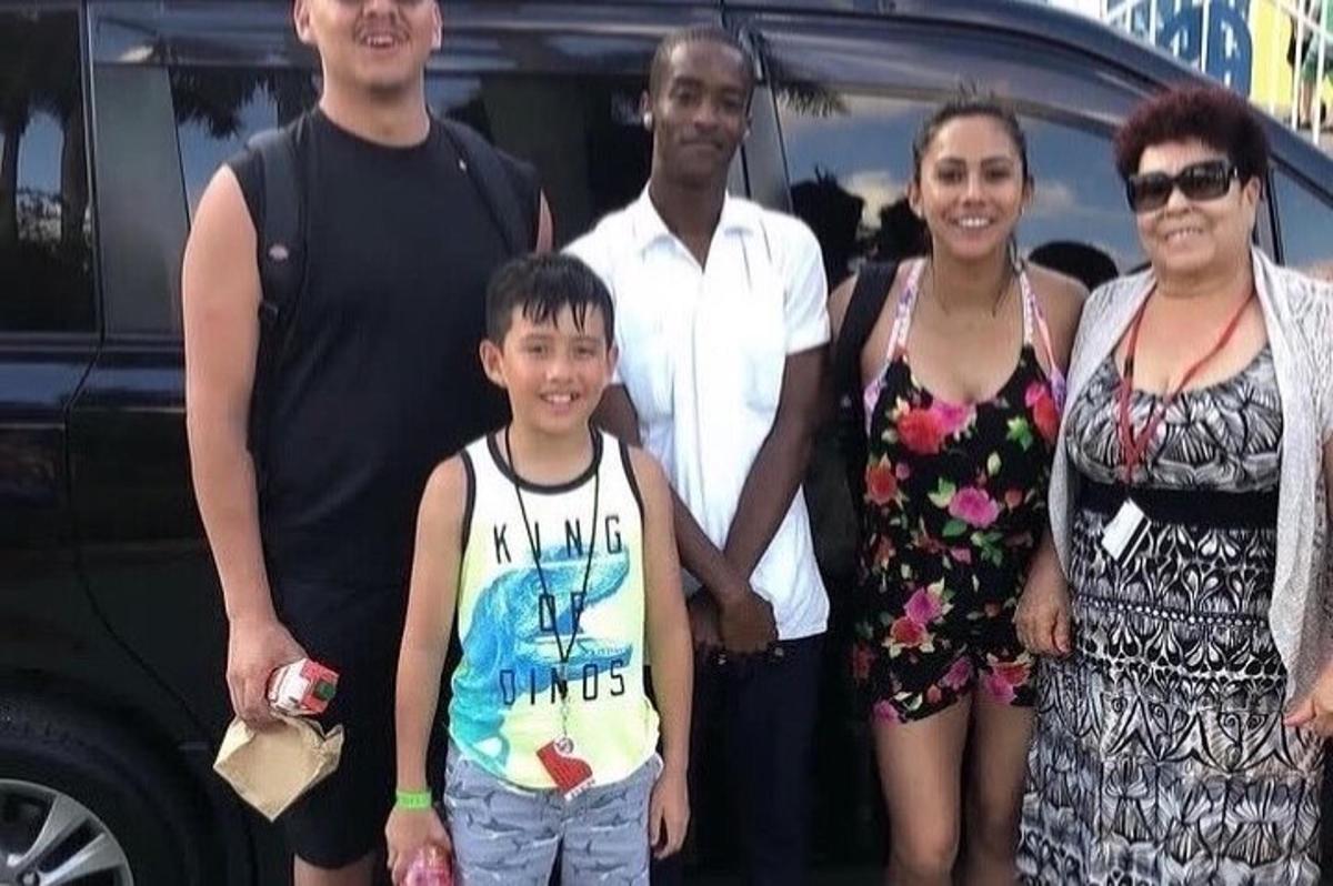 una famiglia in posa per una foto davanti a un'auto