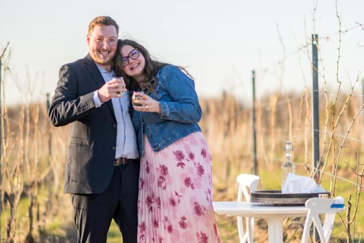 un bărbat și o femeie beau vin în fața unei mese