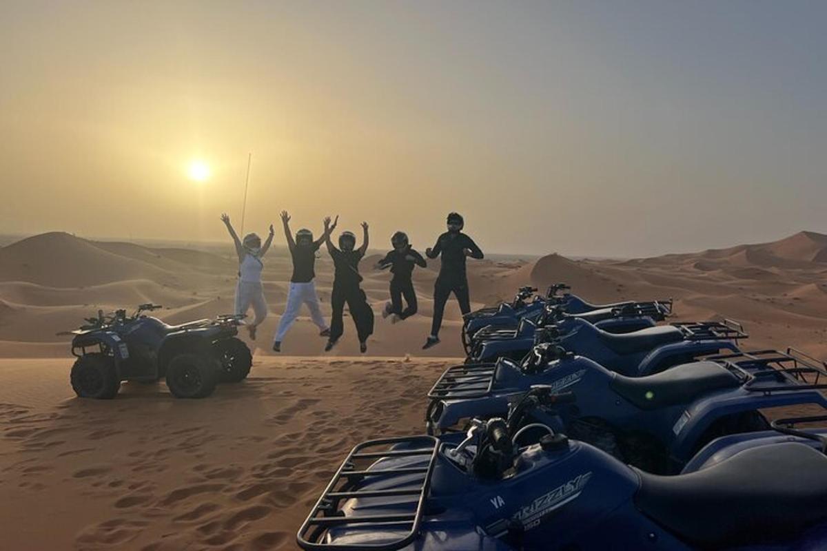 un gruppo di persone che saltano nel deserto con le loro motociclette