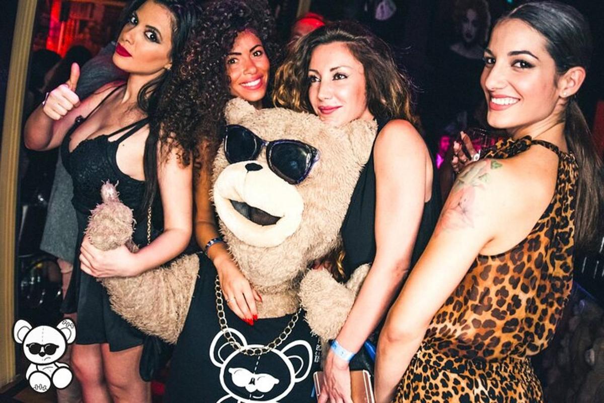 un gruppo di donne in piedi accanto a un orsacchiotto di peluche