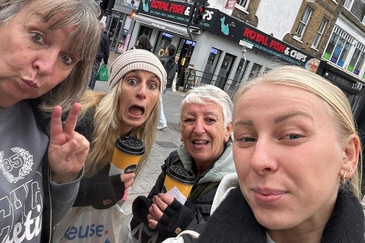 a group of women standing on a street with drinks
