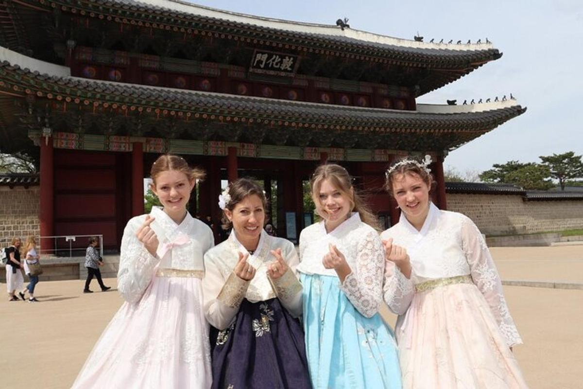 four young girls in traditional dress posing in front of a building