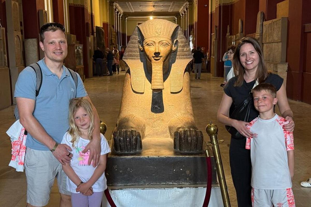 eine Familie steht vor einer Anubis-Statue