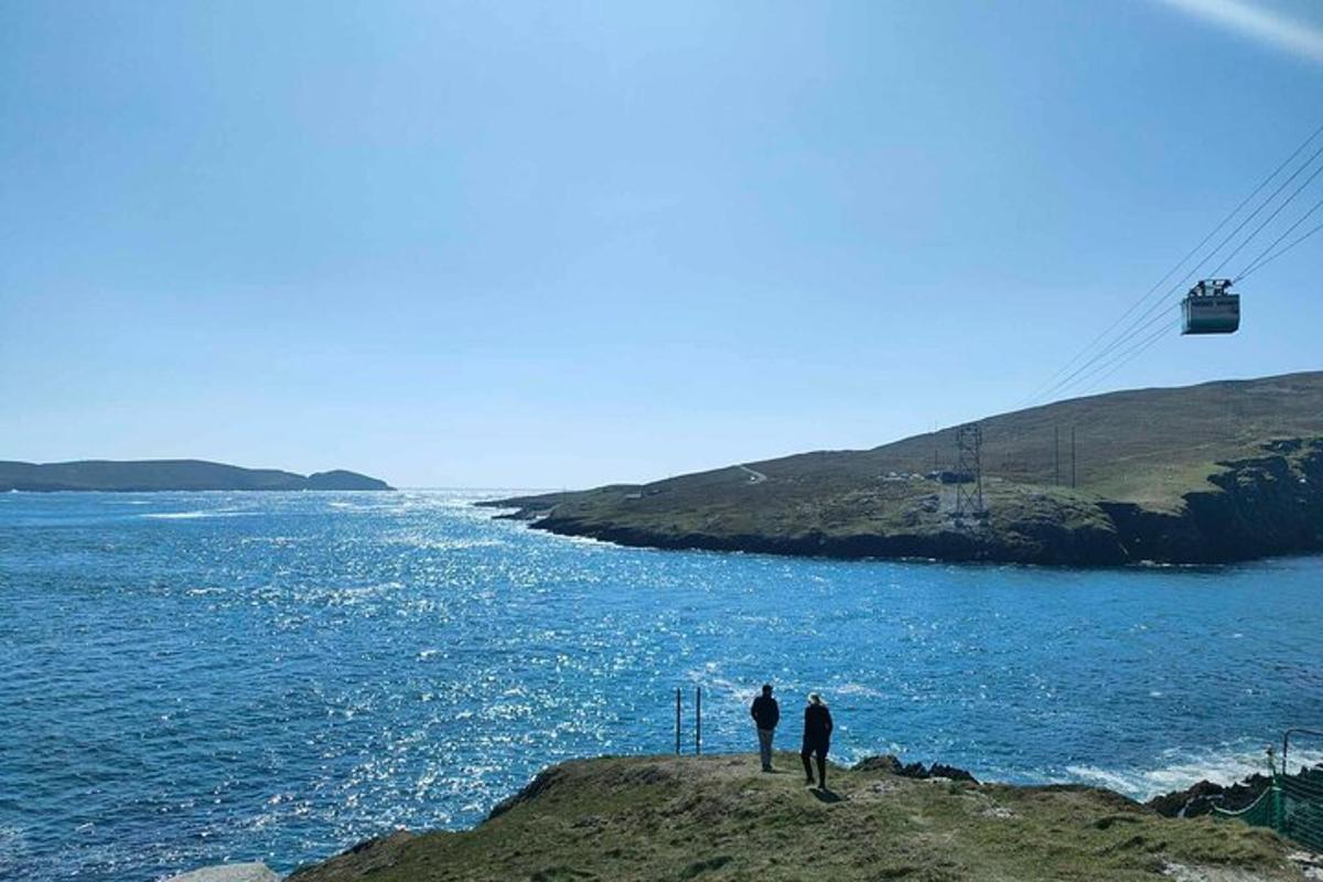 Δύο άνθρωποι στέκονται στην άκρη ενός γκρεμού με θέα τον ωκεανό