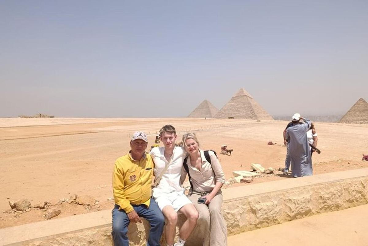 a man and a woman sitting in front of the pyramids