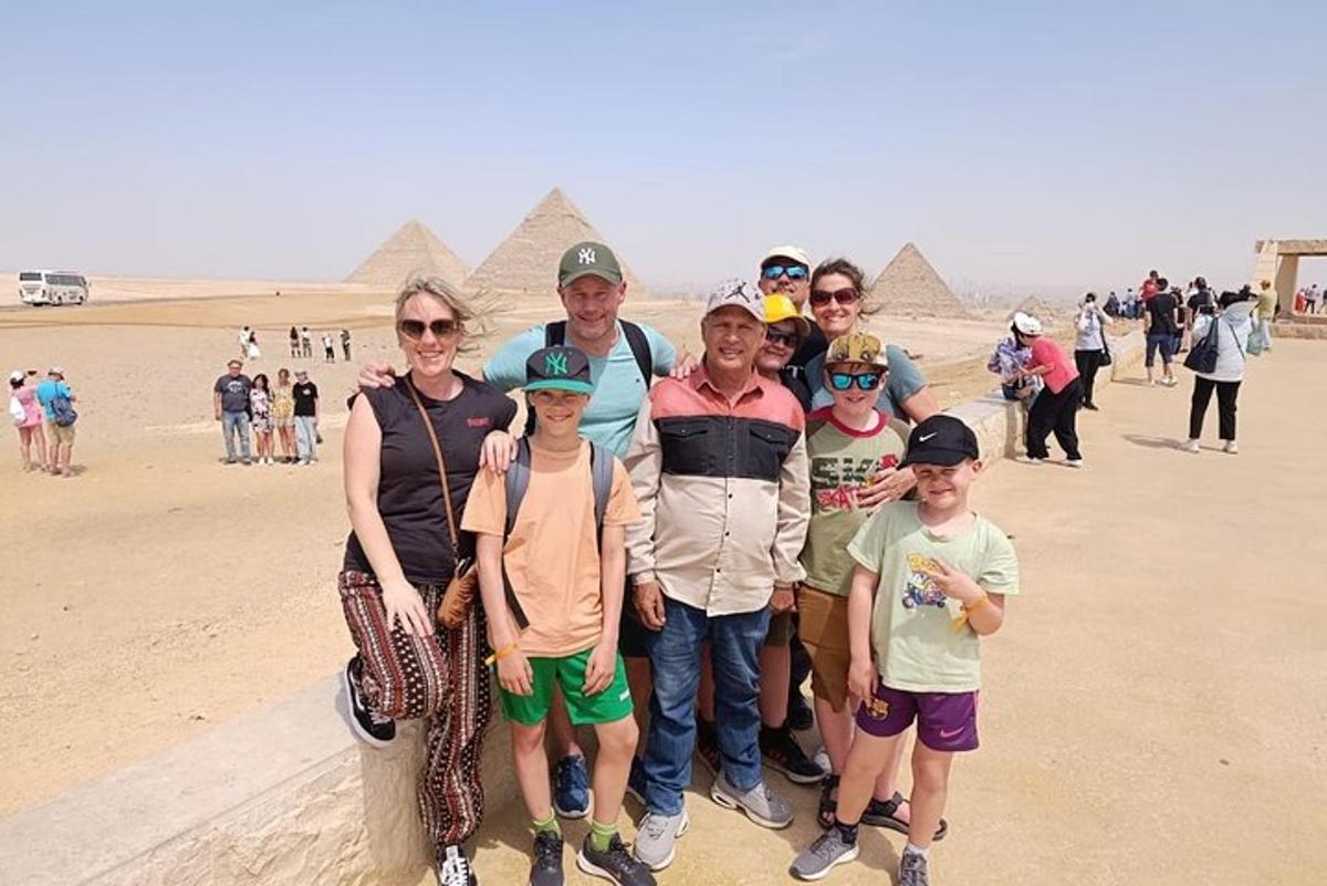 a group of people standing in front of the pyramids