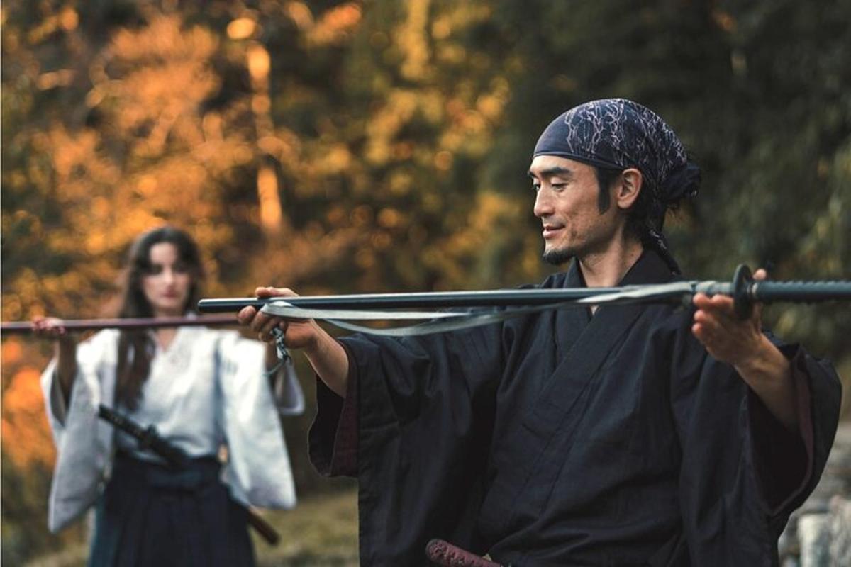 a man holding a rifle with a woman in the background