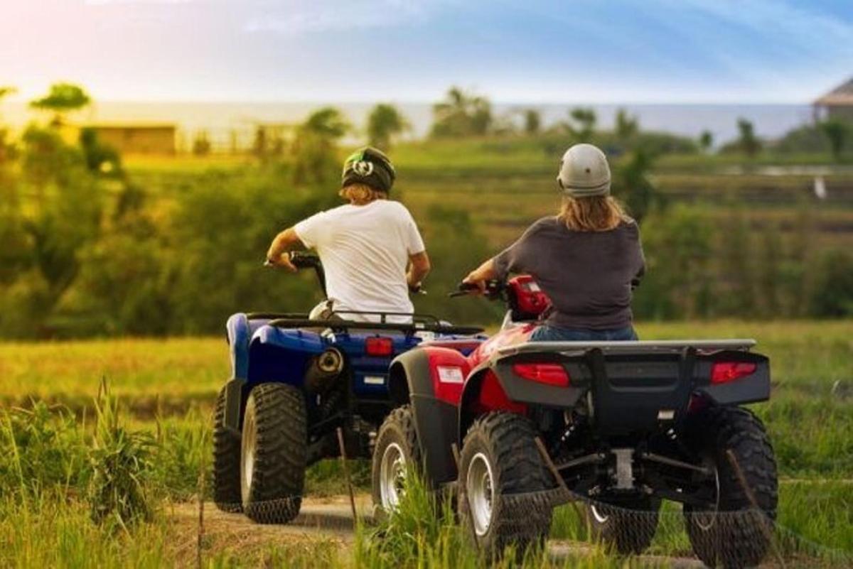 Dos personas viajando en vehículos todo terreno por un camino de tierra