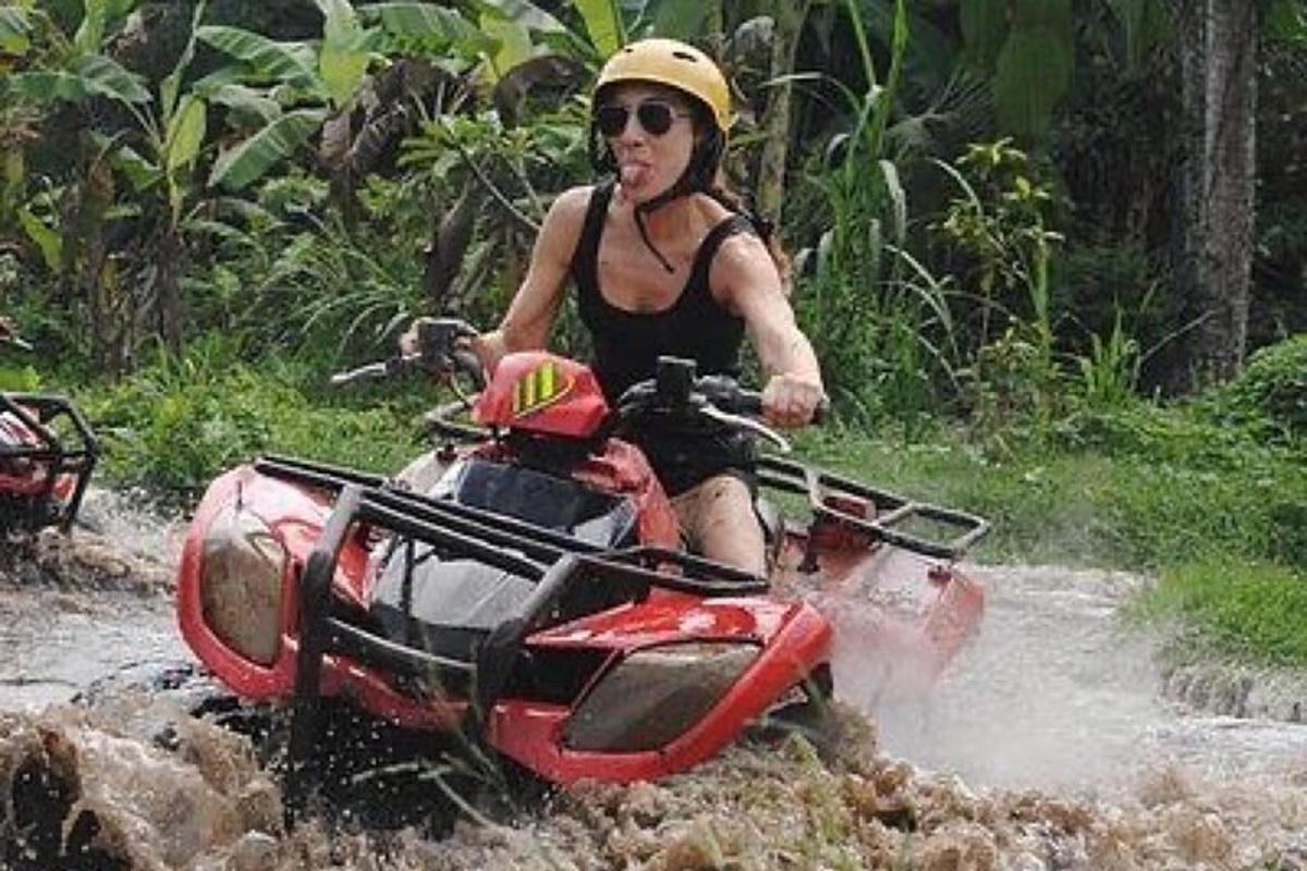 a woman riding a atv through the water