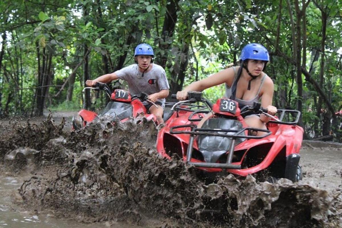 Dos personas viajando en vehículos todo terreno en el barro