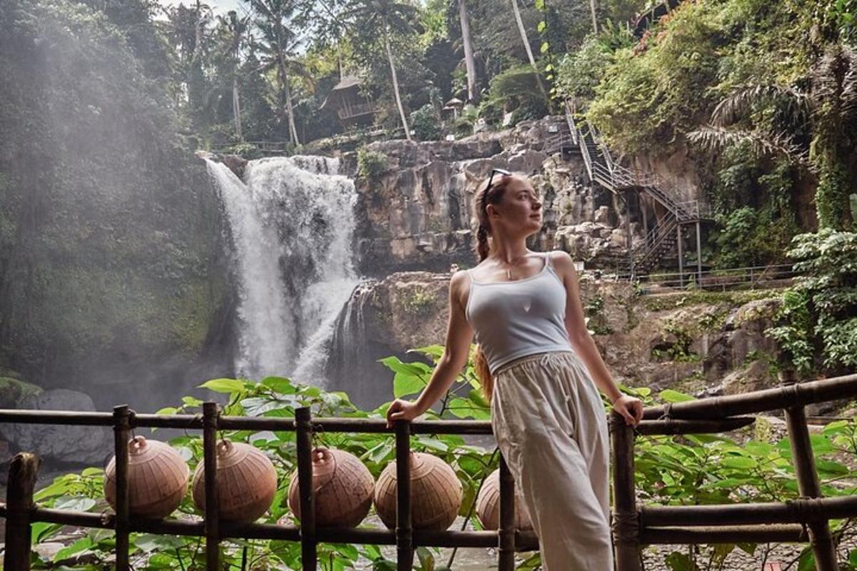 uma mulher parada em frente a uma cachoeira