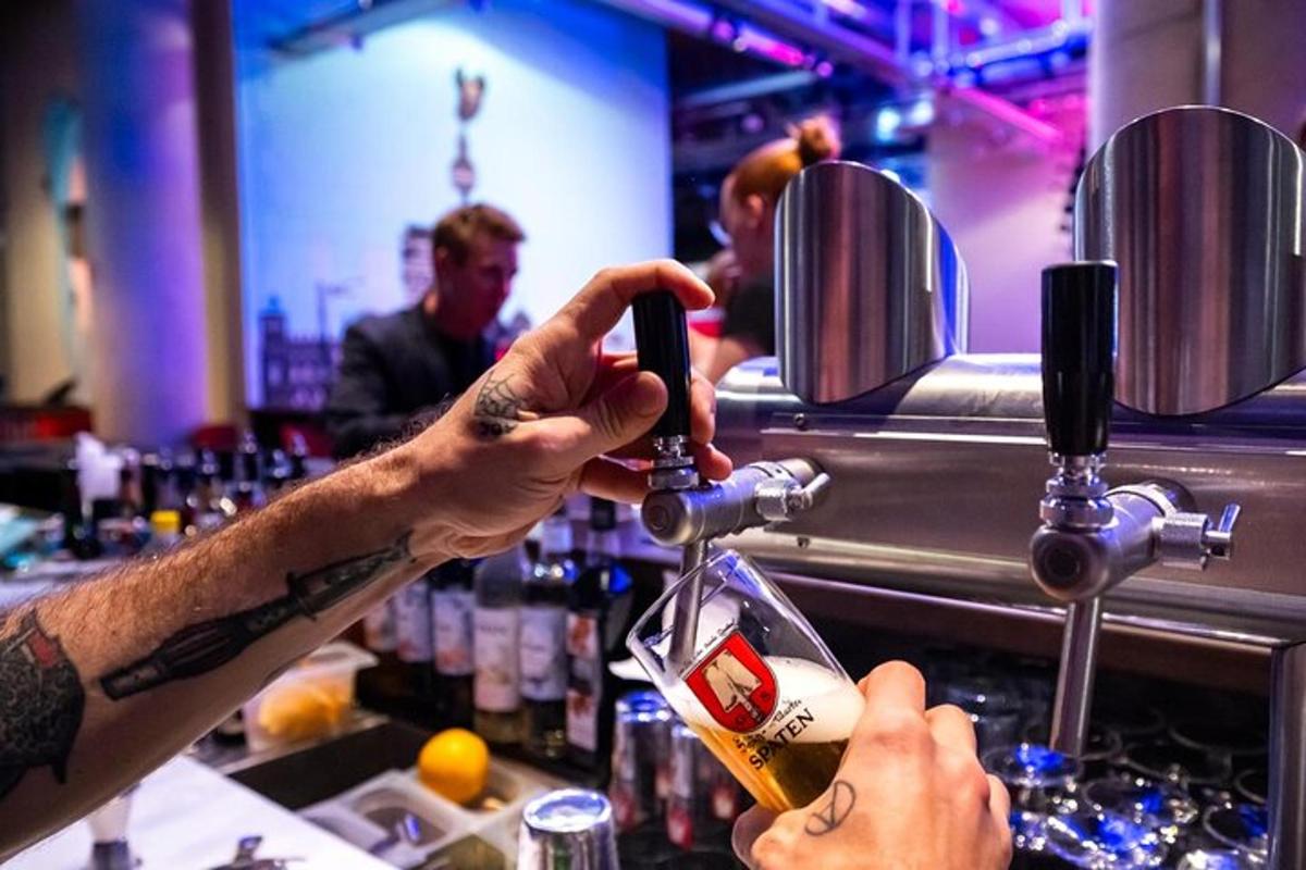 Un hombre sirviendo una bebida en un vaso en un bar.