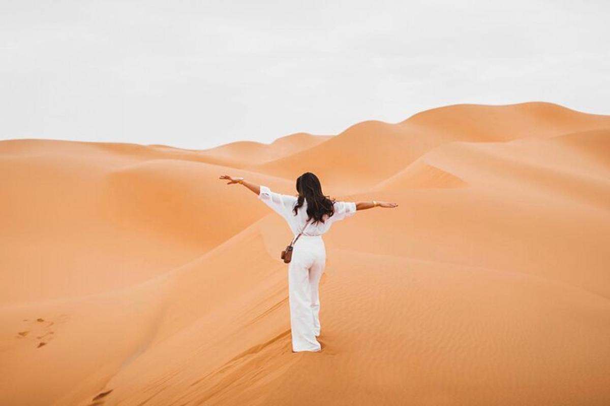 uma mulher no deserto com os braços estendidos