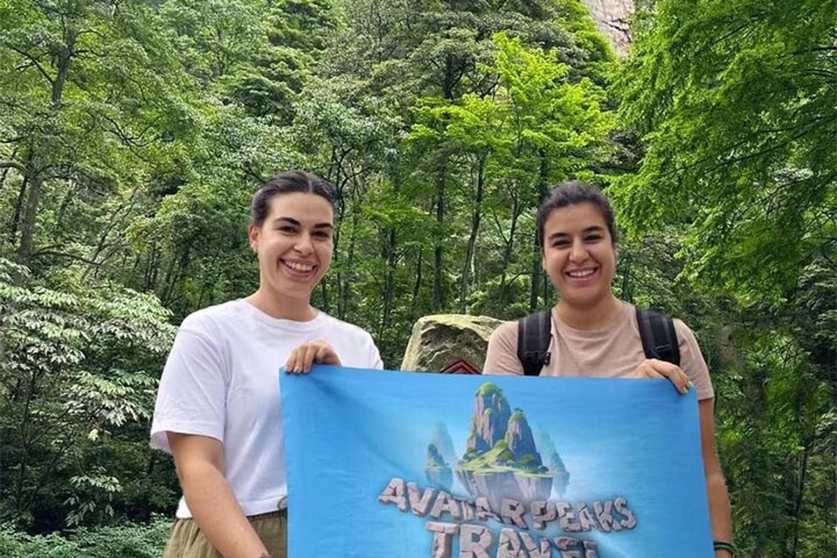 dues persones sostenint un cartell davant d'un bosc