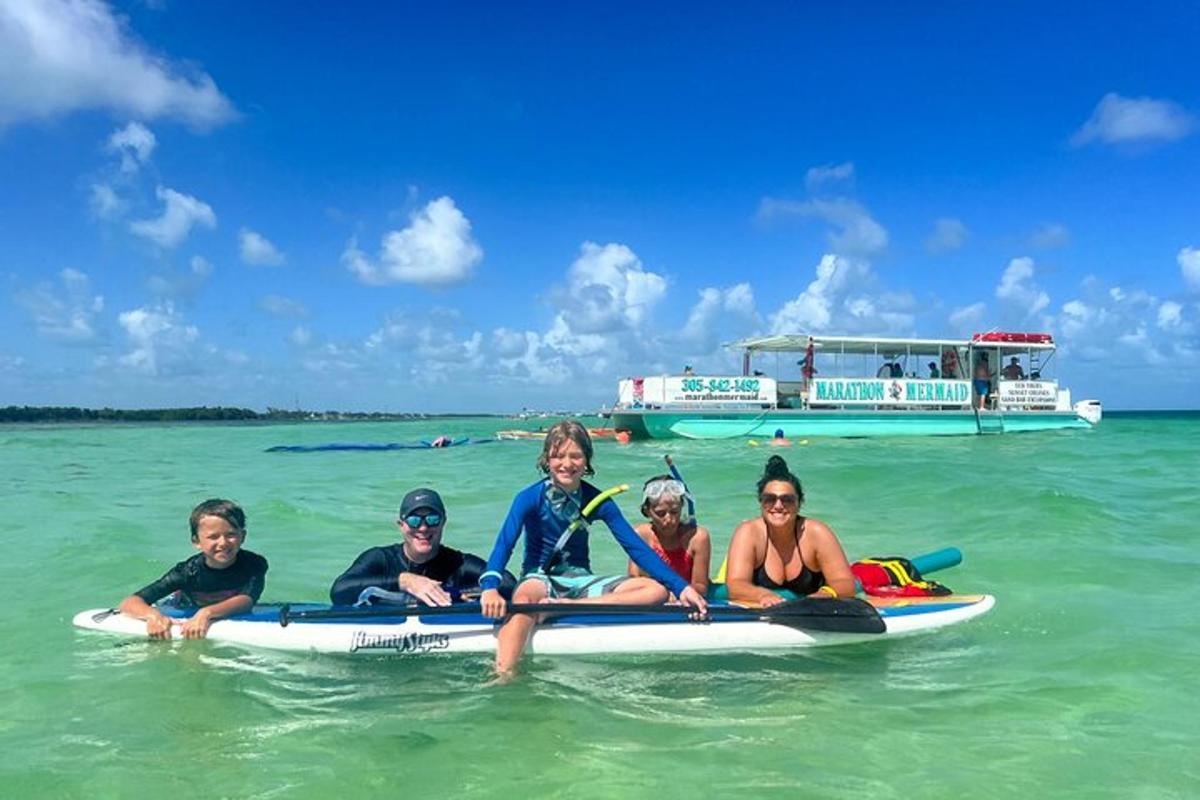 a group of people sitting on a surfboard in the water
