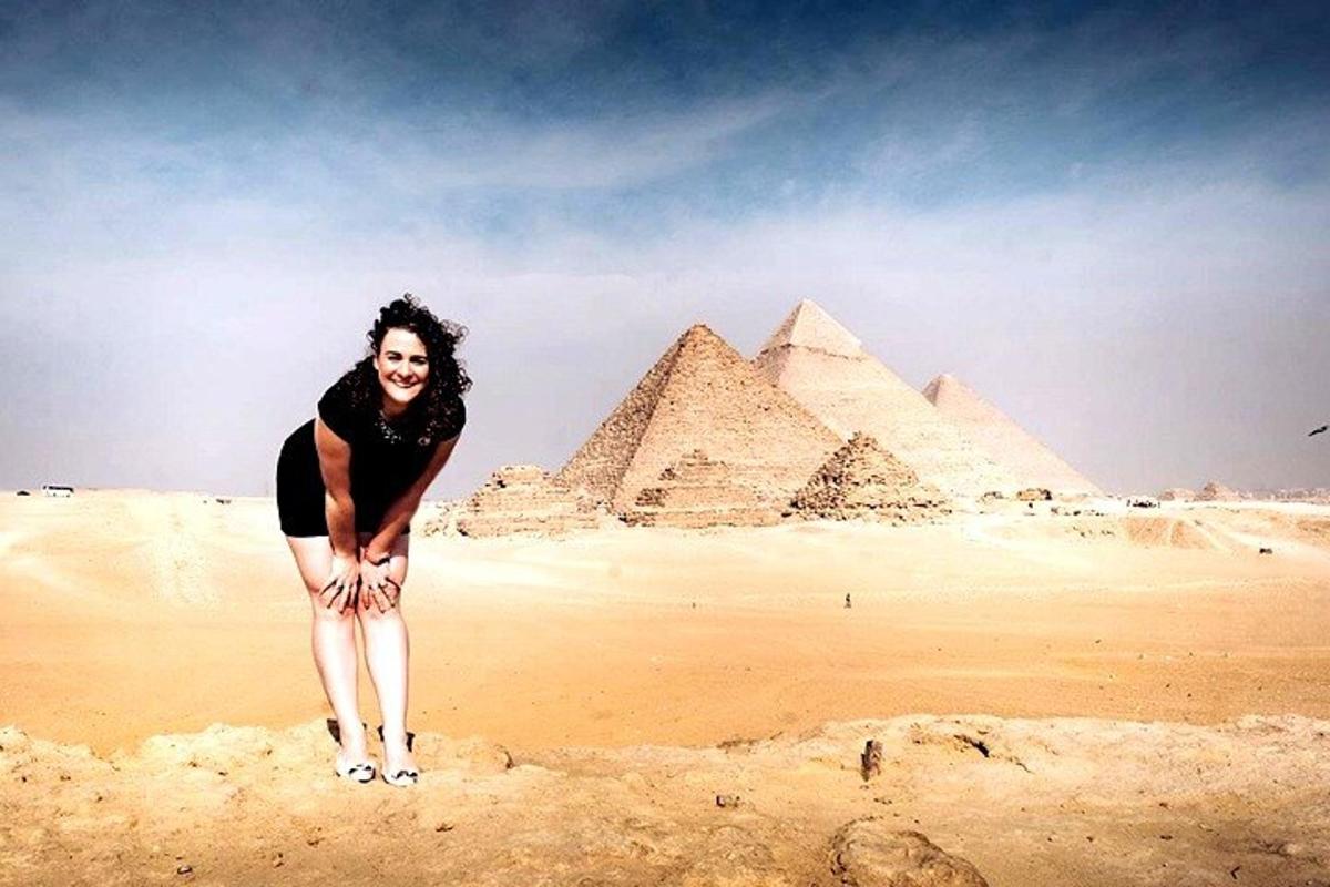 una donna è in piedi davanti alle piramidi