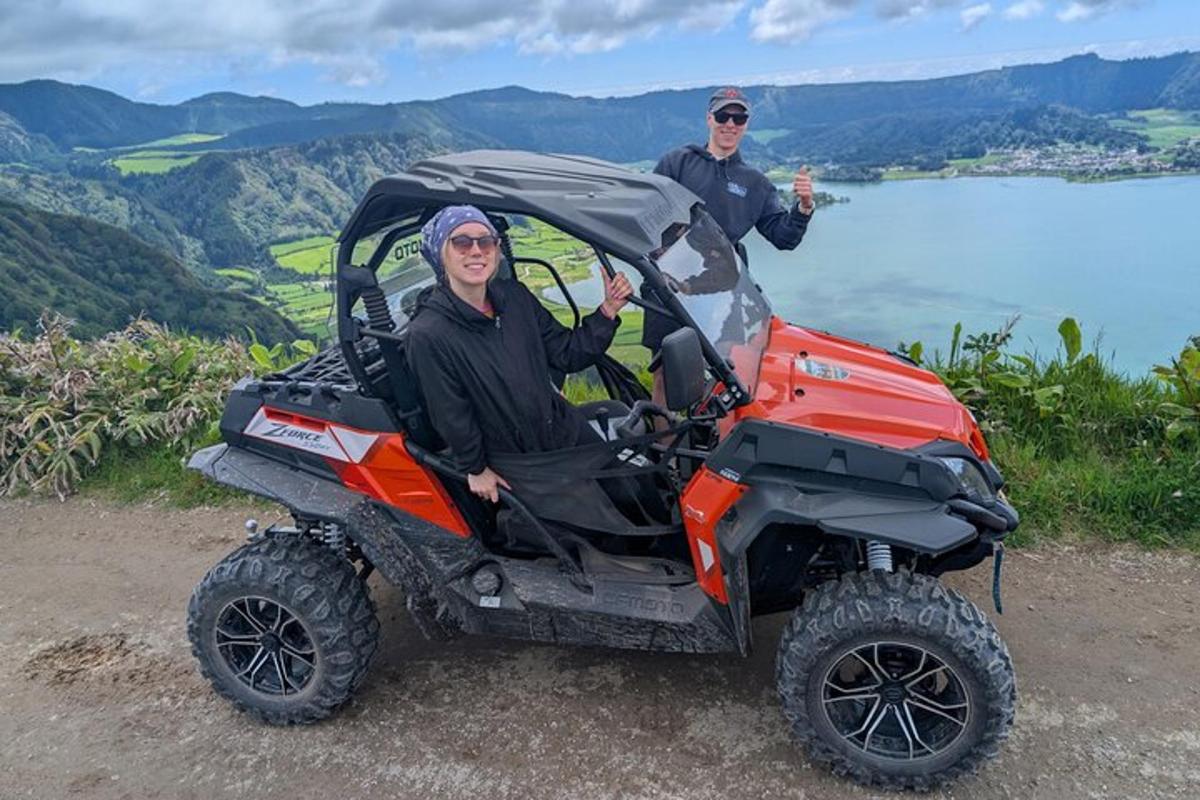 two men are standing next to a atv vehicle