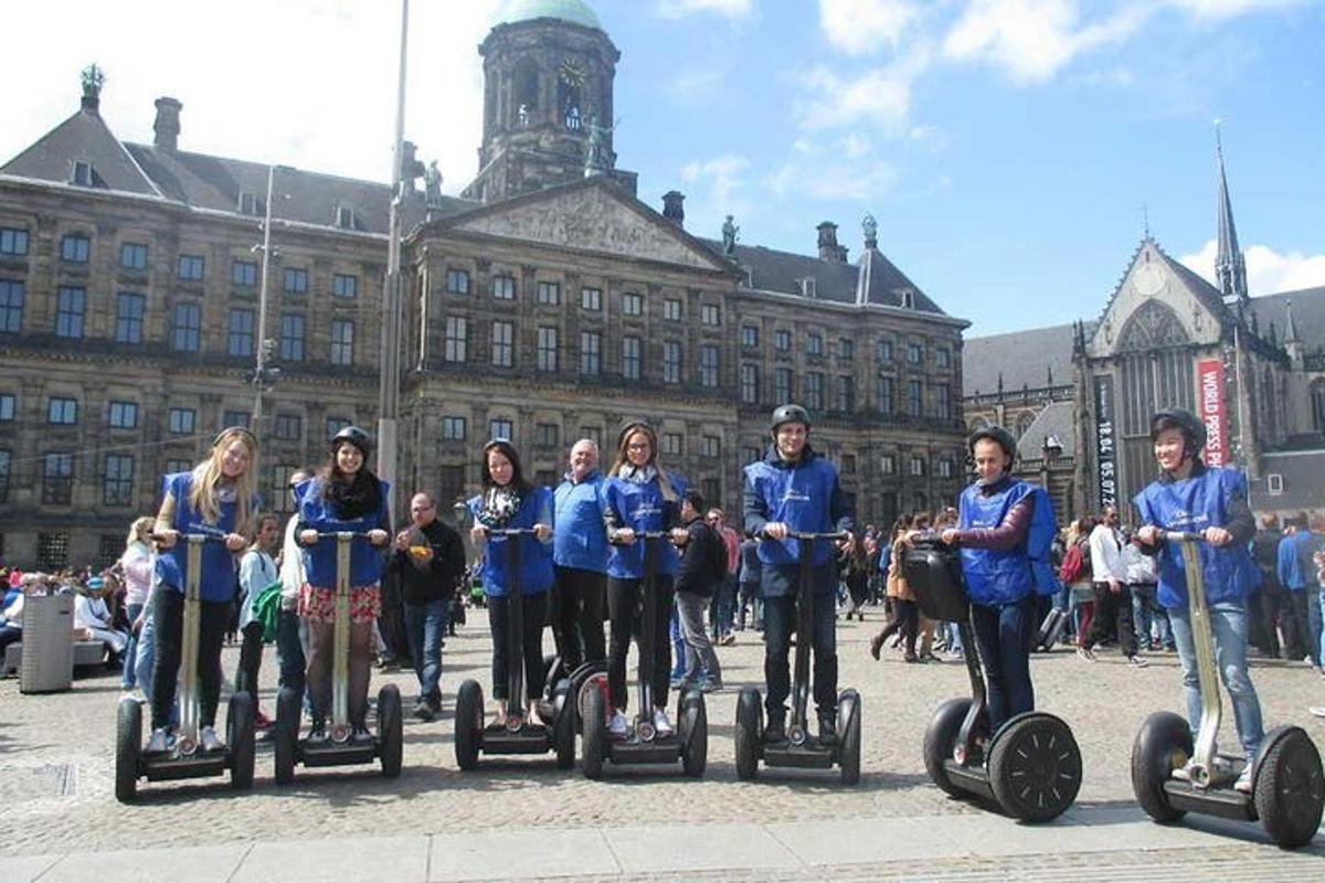 skupina lidí jedoucích na segwayích před budovou