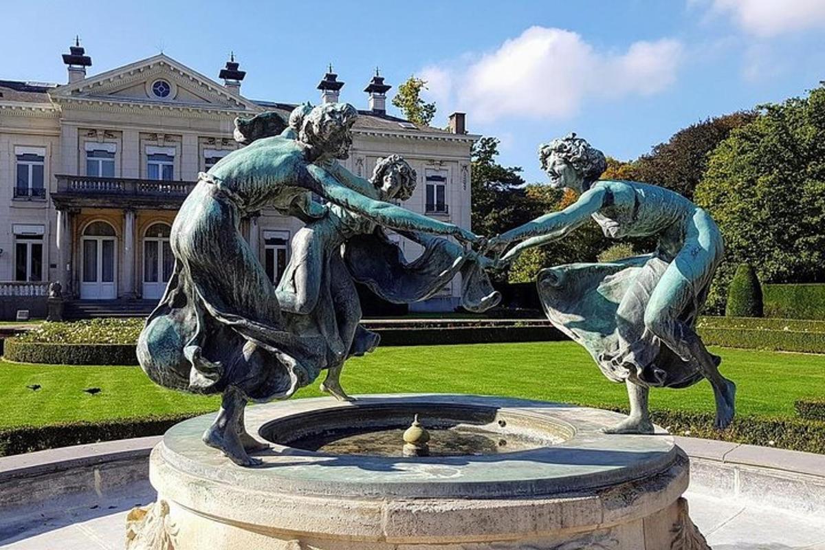 Una estatua de dos mujeres en una fuente frente a un edificio.