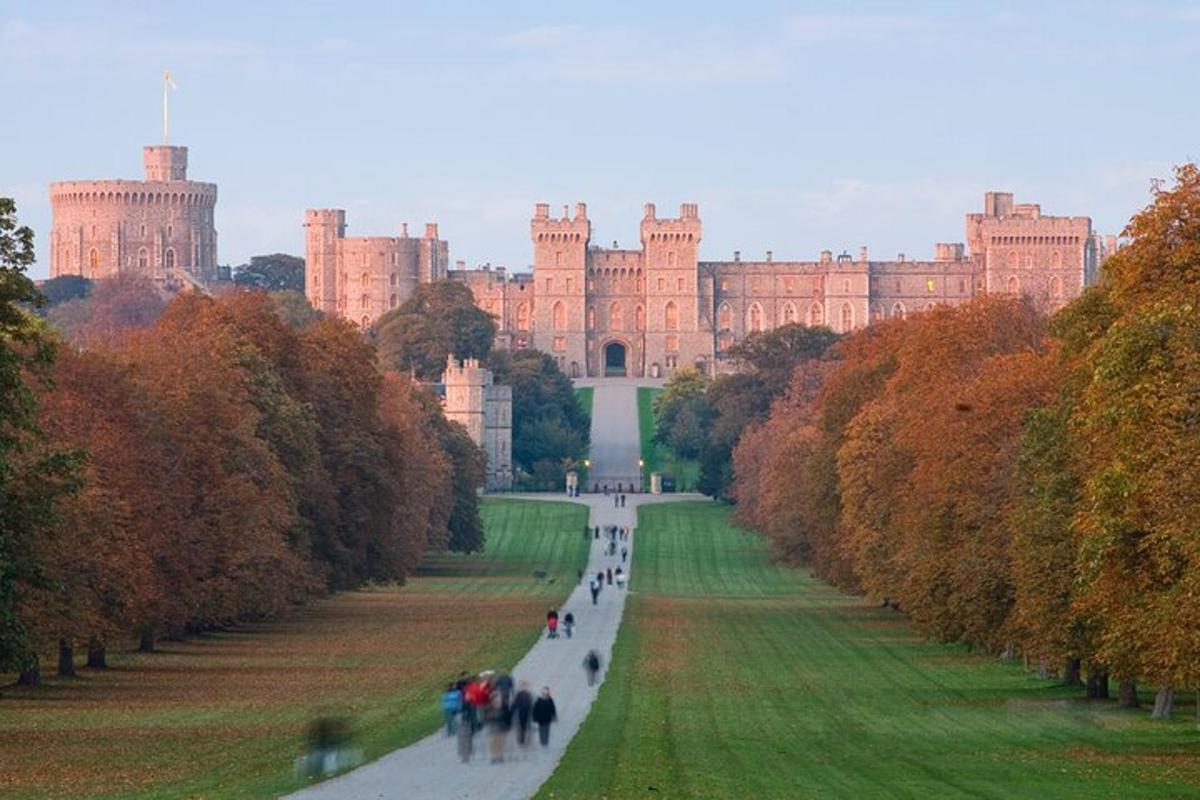 a large castle in the distance with people walking down a road