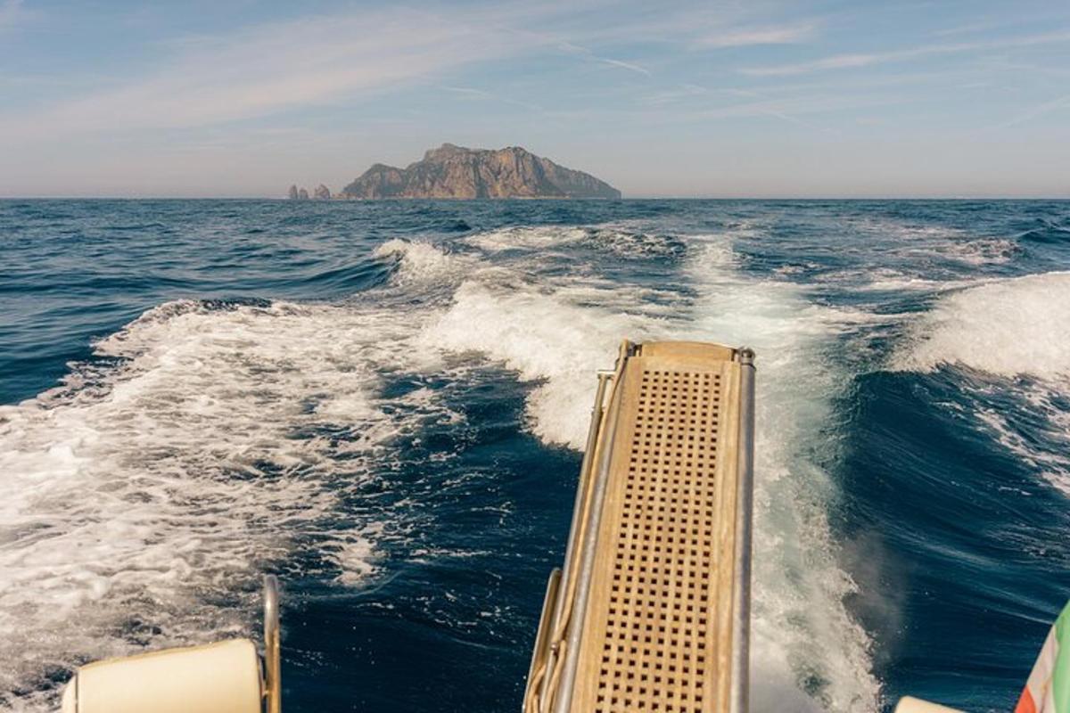 μια βάρκα στον ωκεανό με ένα βουνό στο φόντο