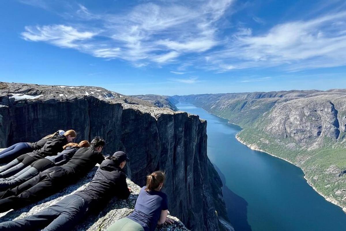 a group of people sitting on the edge of a cliff