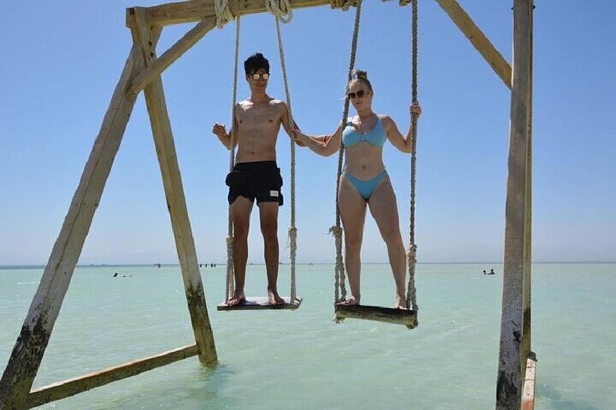 hai người đang ngồi trên xích đu trên bãi biển