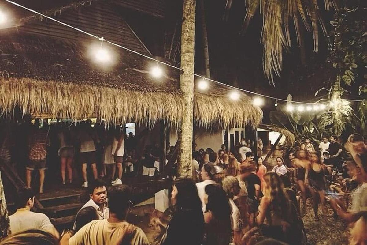 a crowd of people standing outside a bar at night
