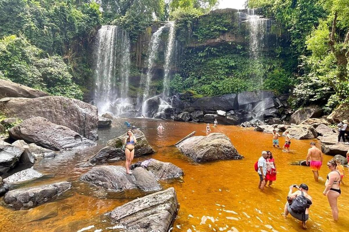 un grup de persones a l'aigua davant d'una cascada