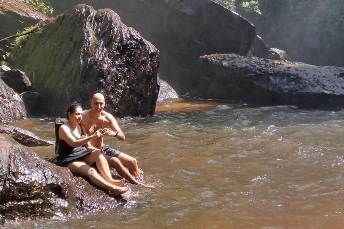 un home i una dona asseguts en una roca al riu