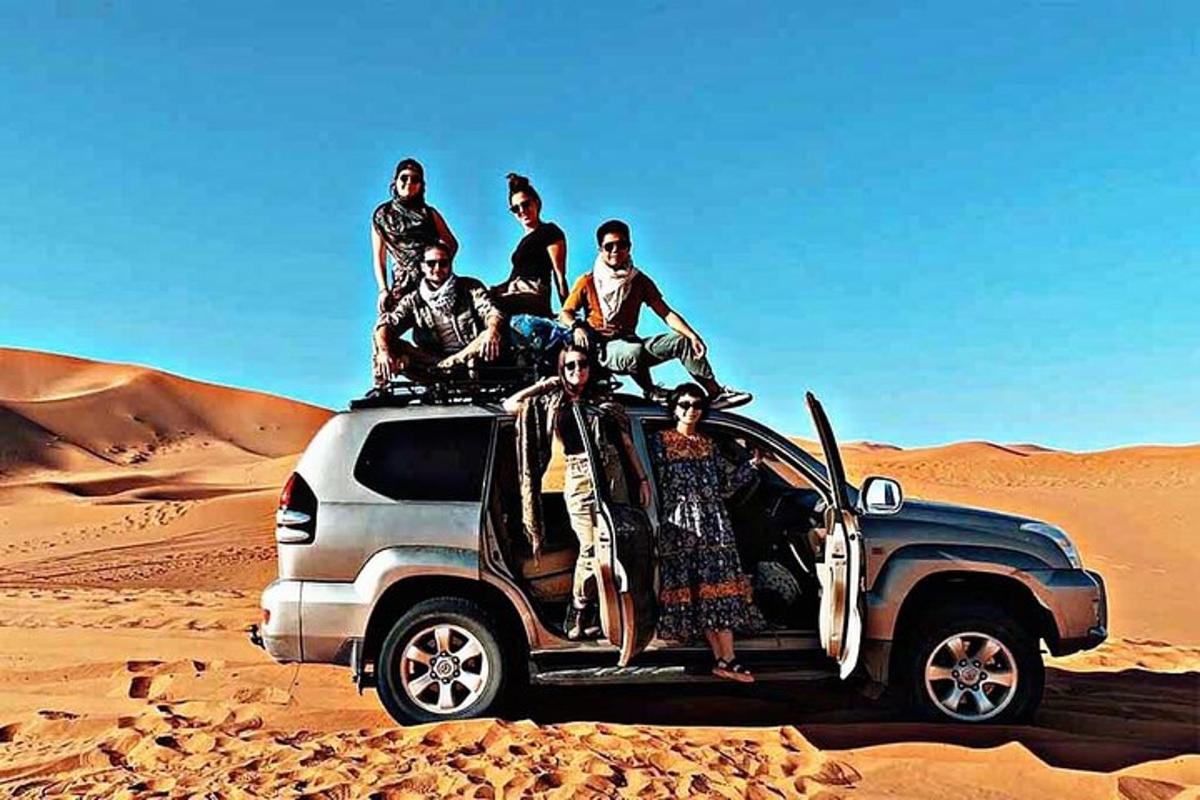 مجموعة من الأشخاص يجلسون على ظهر شاحنة في الصحراء