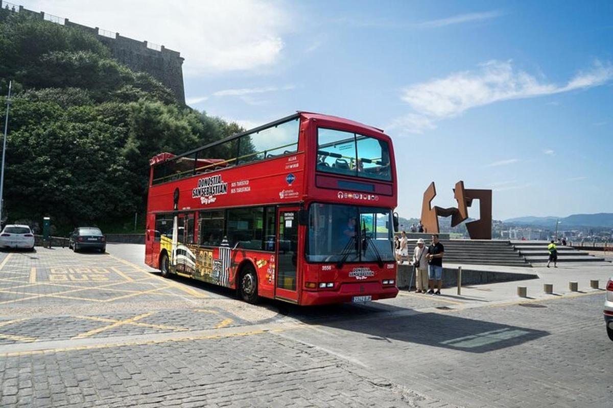 ein roter Doppeldeckerbus fährt eine Straße entlang