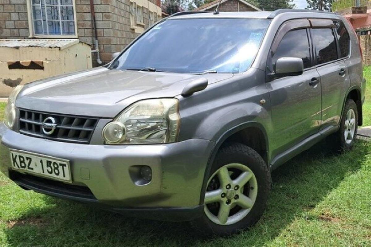 sebuah suv hijau diletakkan di atas rumput di halaman