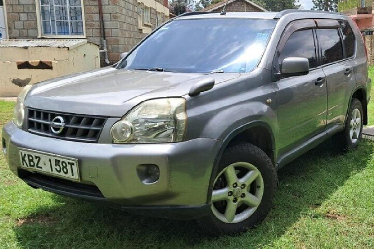 sebuah suv kelabu diletakkan di atas rumput di halaman
