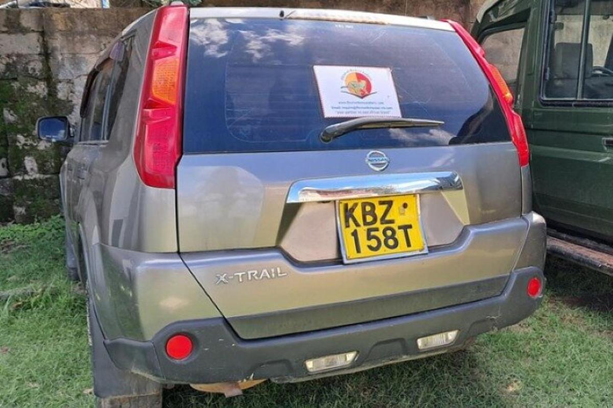 sebuah kereta diletakkan di rumput dengan plat lesen