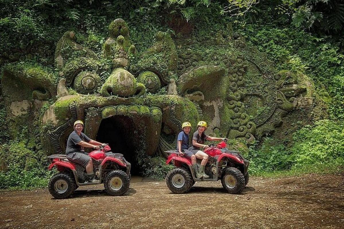 drie mensen rijden op quads voor een tunnel