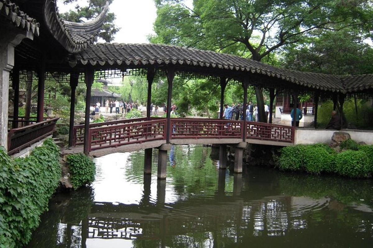 a bridge over a river in a garden