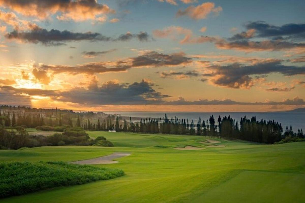 golfiväljak, mille taustal on päikeseloojang